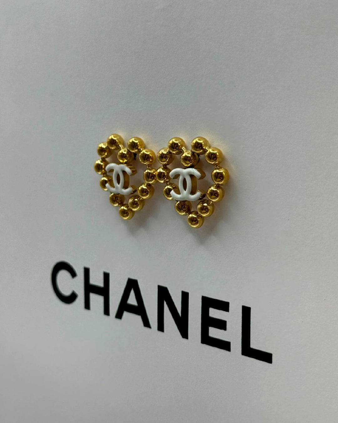 Arete Chanel de corazón dorado con blanco